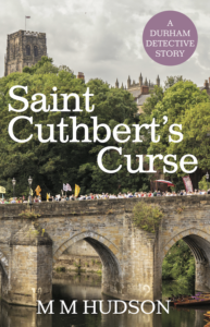 Front cover of detective mystery paperback Saint Cuthbert's Curse by M M Hudson showing Durham Miner's Gala on Elvet Bridge with Durham Cathedral in the background.
